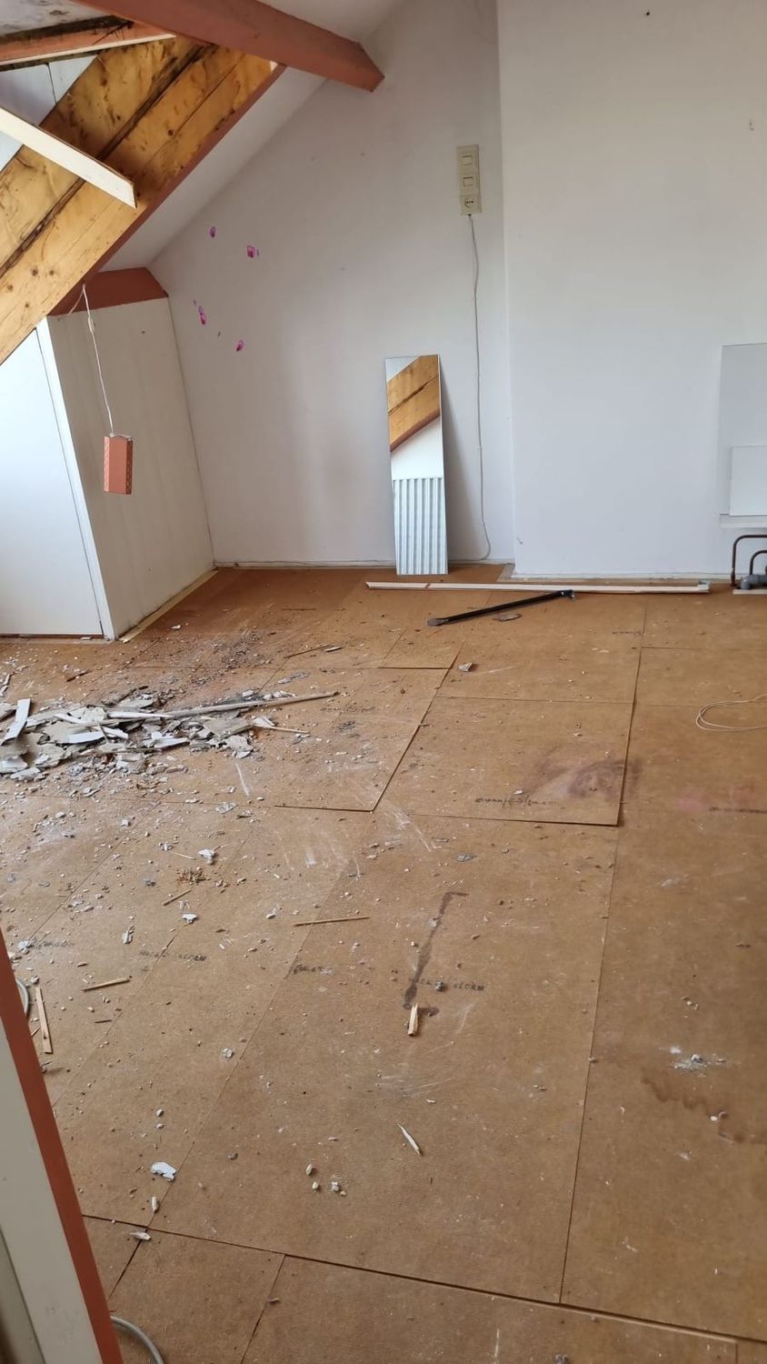 Zoldervloer met zichtbare dakbalken en gruis op de vloerplaten